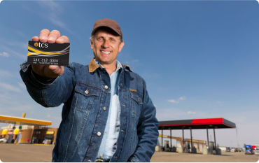 Man holding TCS fuel card at a truck stop